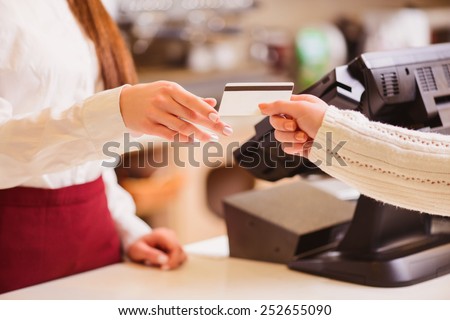 Thanks for your purchase. Cropped image of a customer paying to shop assistant by a credit card at the cash desk Royalty-Free Stock Photo #252655090
