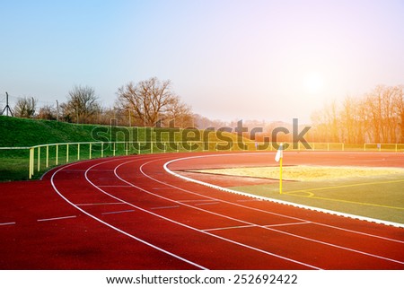 Stock image of a running track in an evening sunset signifying concept of dreams and aspirations Royalty-Free Stock Photo #252692422