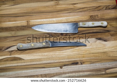 Old, Worn Chef's Knives on a Teak Cutting Board