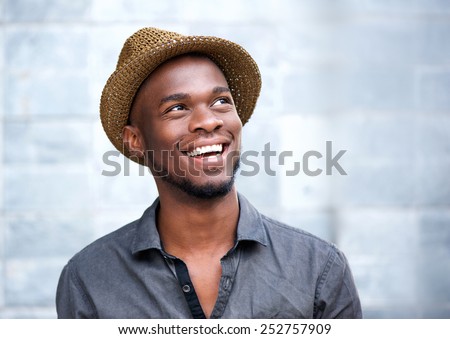 Close up portrait of a happy young african american man laughing against gray background Royalty-Free Stock Photo #252757909