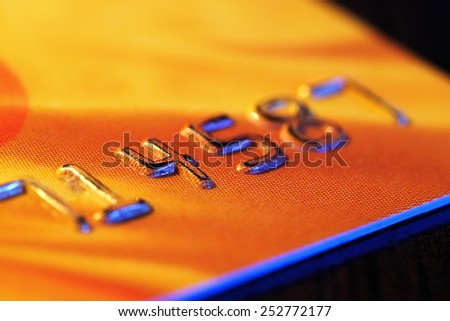 Numbers on plastic card on wooden table, macro view