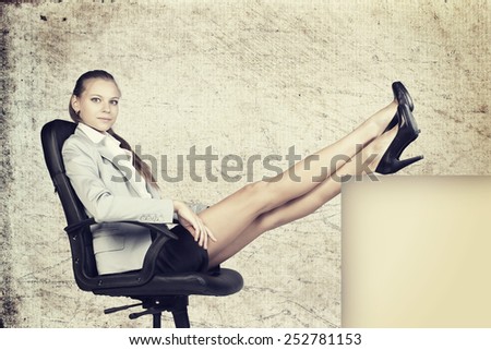 Businesswoman in office chair, looking at camera, with her feet up on anything, over grunge scratchy background