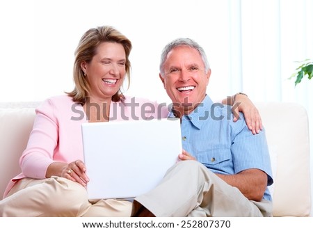 Senior couple looking information at home with computer.
