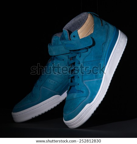 Picture of a pair of blue trainers over a black background