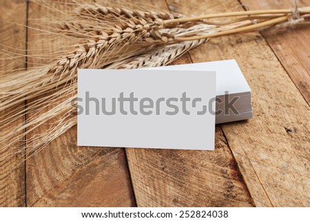 Photo of business cards. Template for branding identity. For graphic designers presentations and portfolios. With wheat spikelets on wooden background. Subject agronomist, agriculture