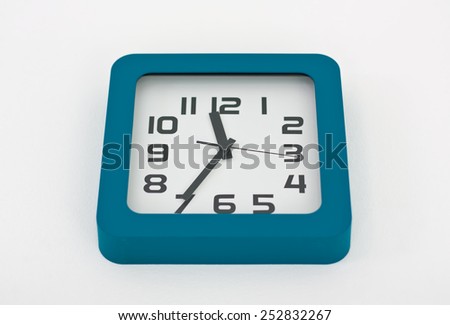 A stylish decorative wall clock hanging from a white wall.