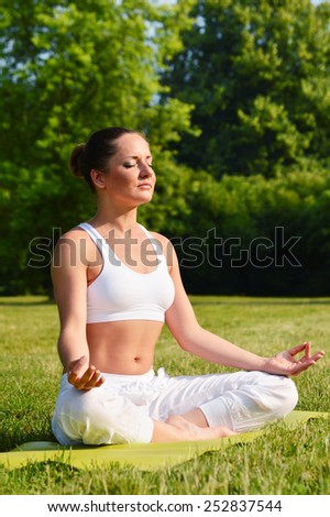 Young woman during yoga meditation in the park.