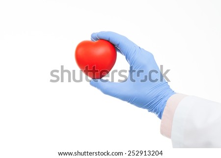 Doctor holding heart shaped toy in hand
