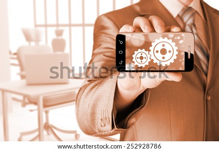 businessman show gear on smartphone to success concept