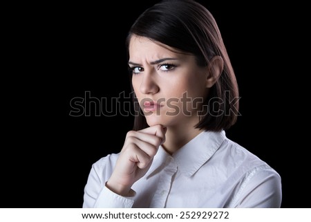 Thinking woman standing pensive contemplating looking skeptic.Thinking business woman expressing  anger,confusion and distrust.Young brunette looking curious,evaluating something