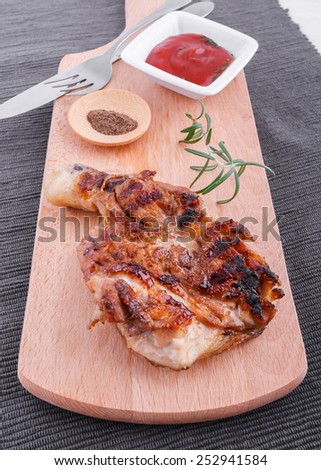 Succulent thick juicy portions of grilled fillet steak served with tomatoes  dip  on an old wooden board