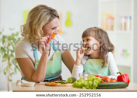 kid and mother eating healthy food vegetables Royalty-Free Stock Photo #252952156