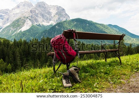 Hanging backpack and hiking shoes with mountains in the background. South Tyrol. Royalty-Free Stock Photo #253004875