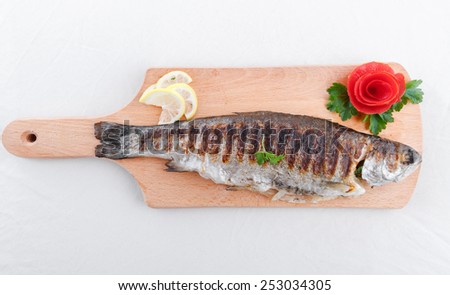 Grilled fish and vegetables on an wooden board