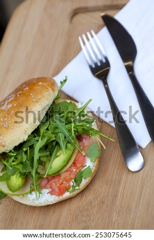 Hamburger with avocado, smoked salmon, apple and green salad