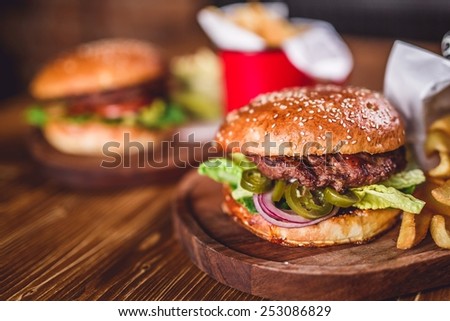 Fresh burger closeup on wooden table.