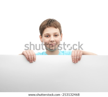 Happy young boy in a cyan t-shirt with a empty copyspace sheet of paper in front of him, composition isolated over the white background