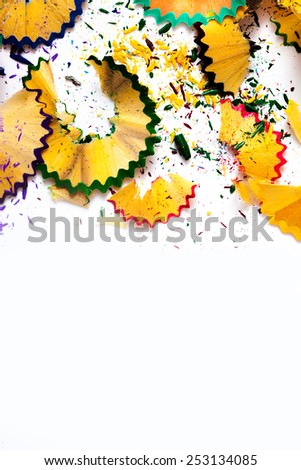 colored pencil shavings on white background with copy space