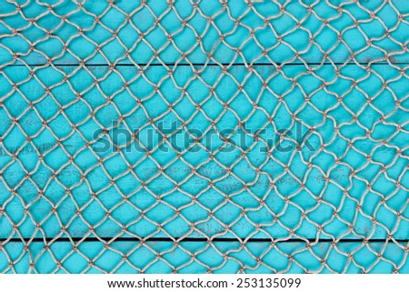 Blank antique teal blue aged wooden sign and fish netting texture background