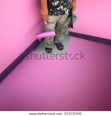 Painters mansion roller dipped in pink paint the walls and floor of room corner until he himself Lock can not go out.  Royalty-Free Stock Photo #253135345