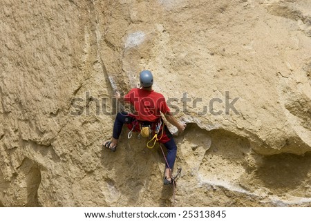 Rock climber searching for the next hold.