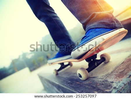 young skateboarder legs skateboarding at skate park