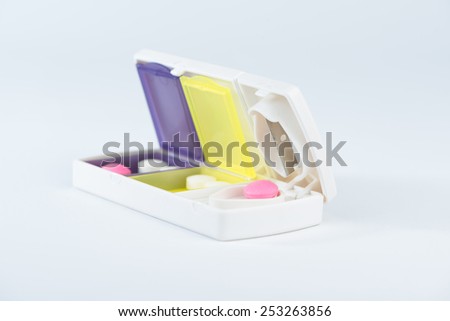 Closed up aluminum blade and pink tablet in pill box