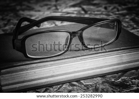 black and white glasses and book