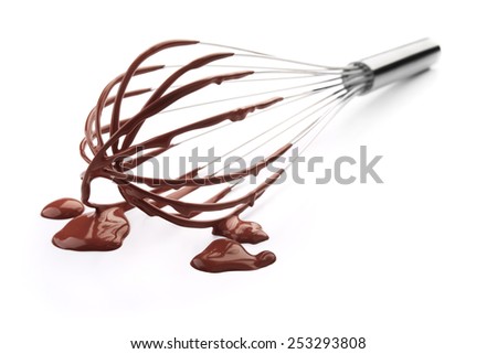 wire whisk with chocolate against white background Royalty-Free Stock Photo #253293808