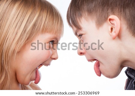 Sister and brother stick out tongues to each other Royalty-Free Stock Photo #253306969