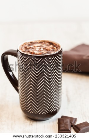 Cup of coffee with whipped cream and melted chocolate on white background