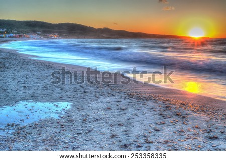 sardinian shoreline under a colorful sky at dusk