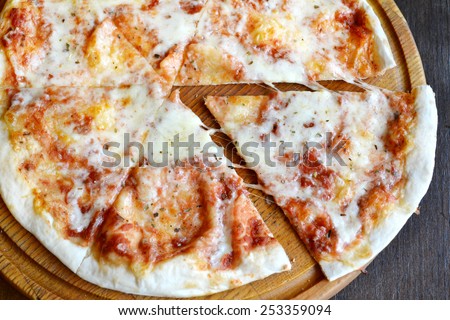Whole pizza margherita on wooden plate
