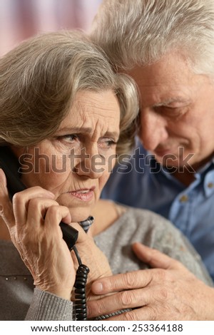 Portrait of  sick senior couple with telephone
