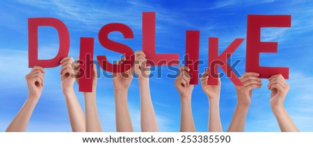 Many Caucasian People And Hands Holding Red Letters Or Characters Building The English Word Dislike On Blue Sky