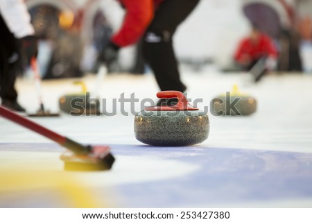 Curling stones on ice Royalty-Free Stock Photo #253427380