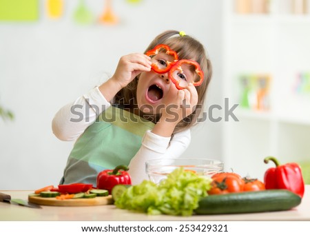 kid girl having fun with food vegetables at kitchen Royalty-Free Stock Photo #253429321