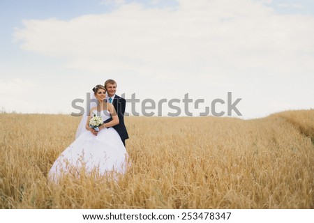 Happy bride and groom on the wheat field