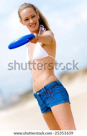 A woman on the beach playing frisbee