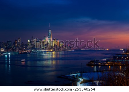 New York City with skyscrapers illuminated over Hudson River panorama.