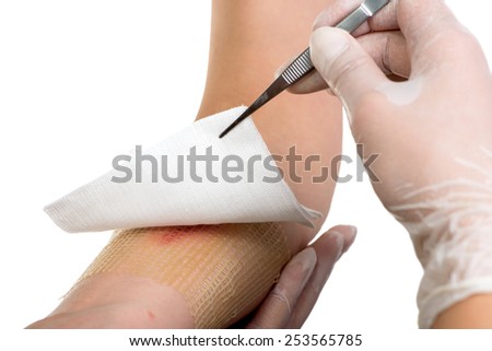 Medical assistant changes the dressing of a wound at the emergency room Royalty-Free Stock Photo #253565785