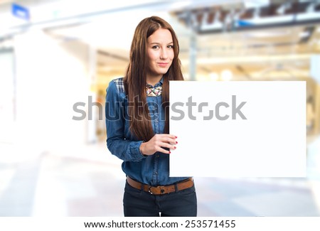 Trendy young woman showing a white canvas. Over shopping center background