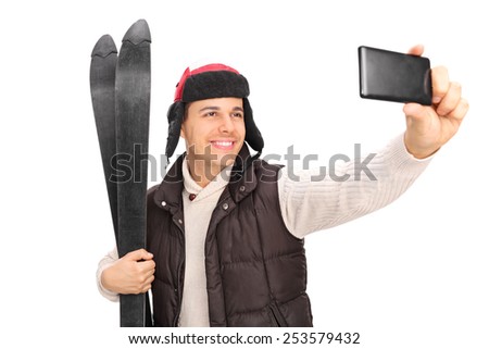 Young guy taking a selfie with his skis isolated on white background