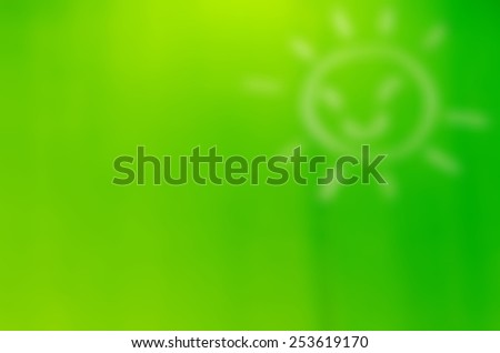 Blurred sun icon on green background