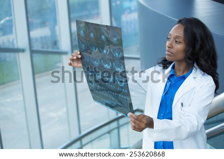 Closeup portrait of intellectual woman healthcare personnel with white labcoat, looking at full body x-ray radiographic image, ct scan, mri, isolated hospital clinic background. Radiology department Royalty-Free Stock Photo #253620868