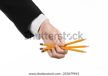 Drawing and Design theme: the hand of the artist in a black suit holding a pencil isolated on white background in studio
