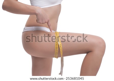 Close-up Of Woman Measuring Her Thigh With A Yellow Metric Tape