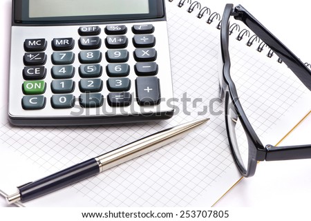 Calculator, pen and glasses isolated on white background