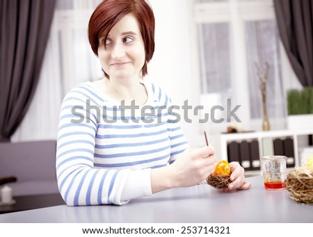 young happy girl with brush and ester eggs for easter holiday 