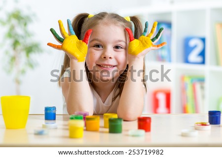 Portrait of kid girl with face and hands painted at home Royalty-Free Stock Photo #253719982